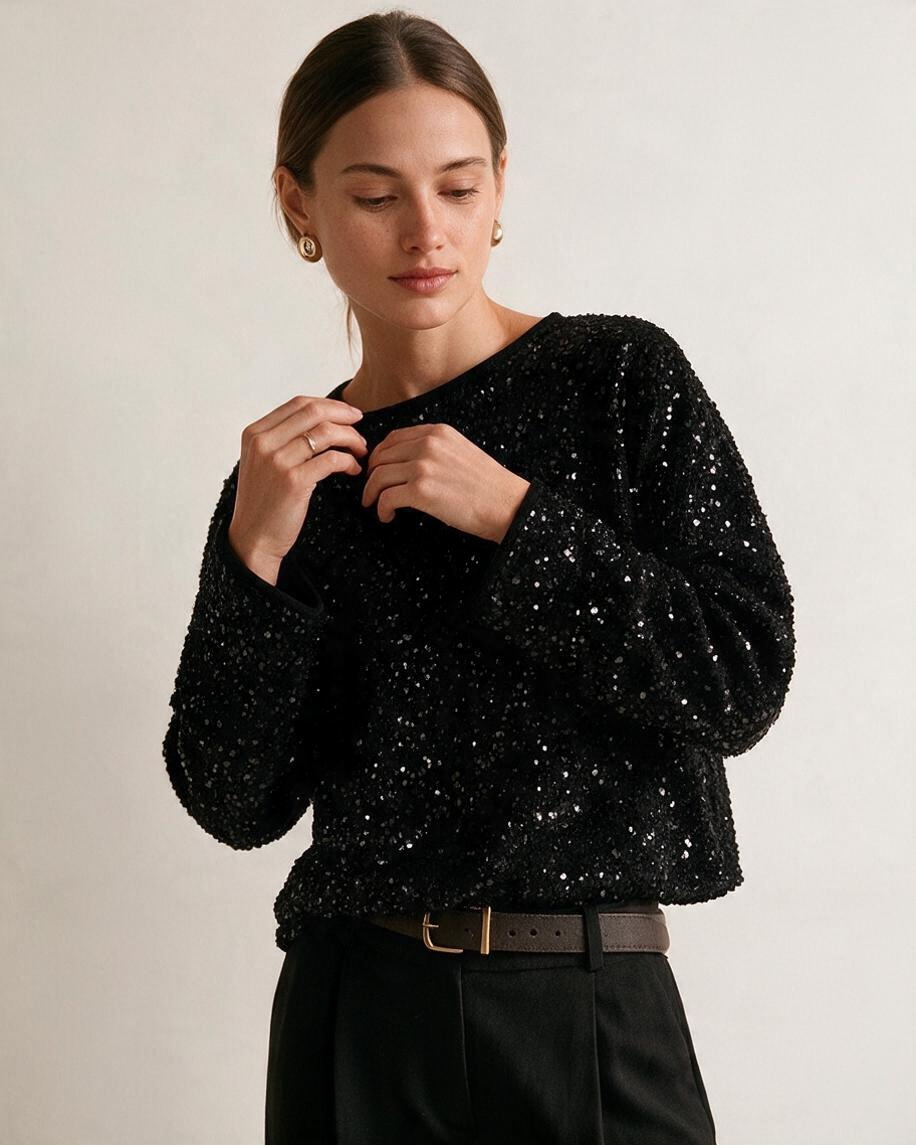Blusa negra de lentejuelas de Yanet Collective con cuello redondo y manga larga, ideal para un look elegante.