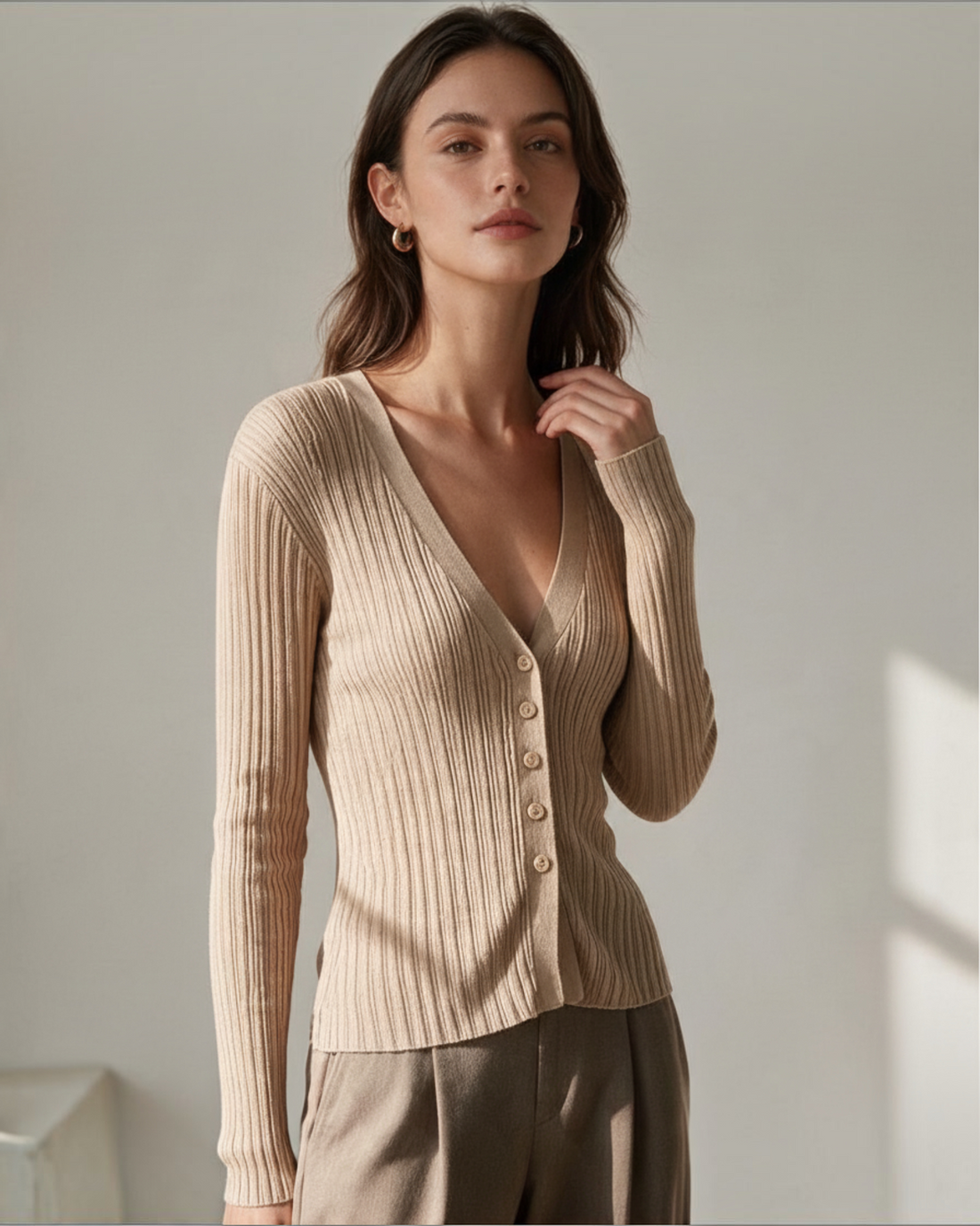 Modelo vistiendo cárdigan Yanet Collective de punto acanalado beige con escote en V y botones frontales