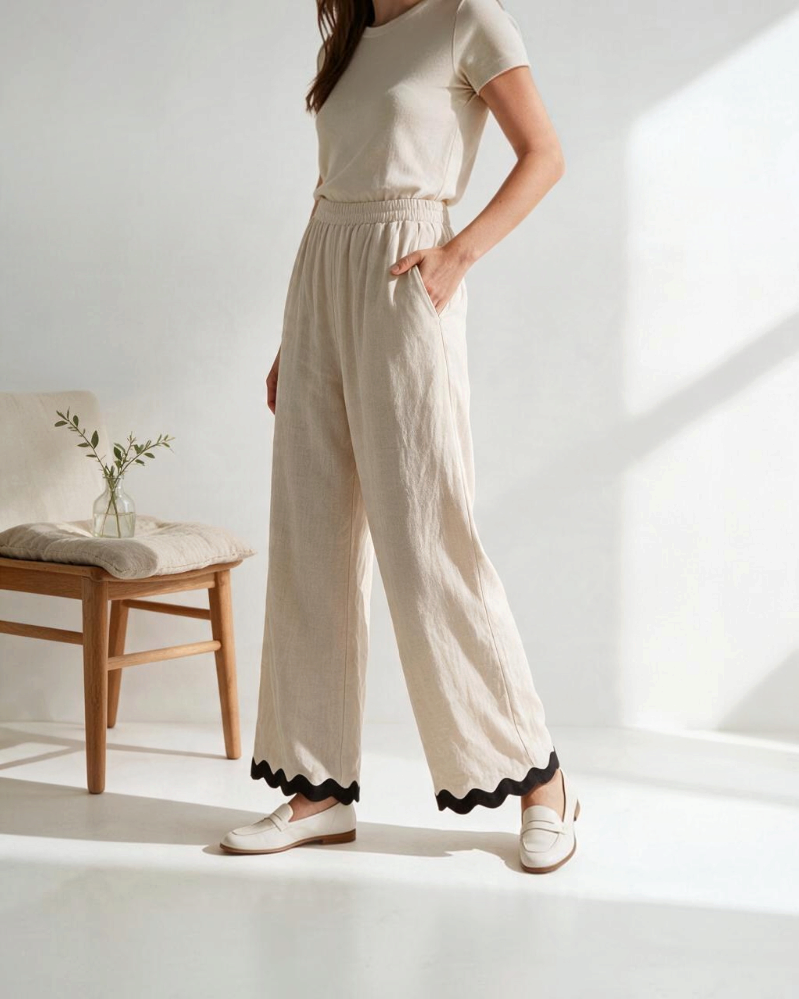 Pantalones wide-leg beige de Yanet Collective con ribete negro en el bajo, cintura elástica y tejido ligero.