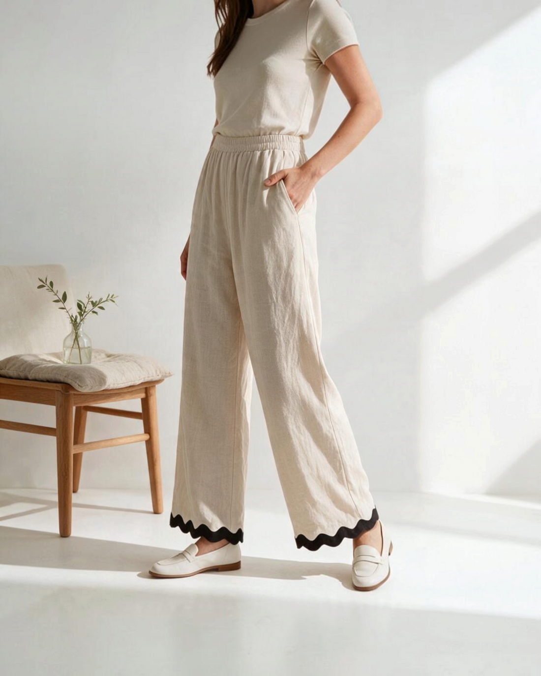 Pantalones wide-leg beige de Yanet Collective con ribete negro en el bajo, cintura elástica y tejido ligero.