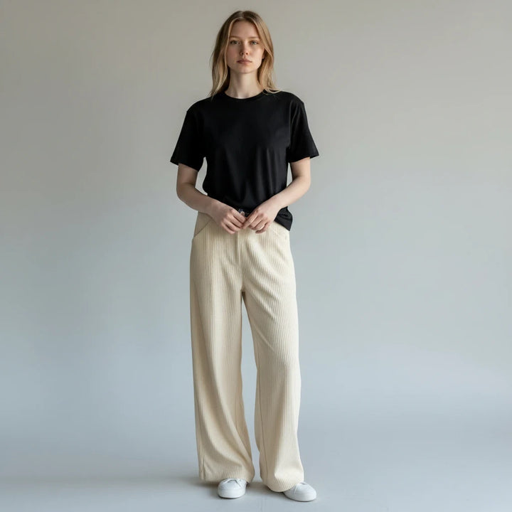 Modelo vistiendo pantalones Yanet Collective beige de pierna ancha con textura y camiseta negra básica